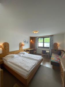 a bedroom with a large bed and a living room at Pension Dorfwirt in Bad Kleinkirchheim