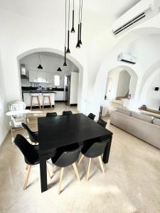 a black dining room table and chairs in a living room at BEAUTIFUL 4-BEDROOM VILLA WITH POOL AND VIEWS OF THE LAGOON AND GOLF COURSE -minimum stay of 4 nights in Hurghada