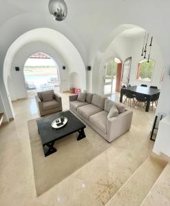 a living room with a couch and a table and a piano at BEAUTIFUL 4-BEDROOM VILLA WITH POOL AND VIEWS OF THE LAGOON AND GOLF COURSE -minimum stay of 4 nights in Hurghada