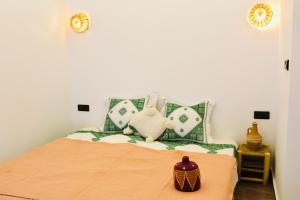 a bedroom with a bed with green and white pillows at TRAVEL SURF NATURE in Tamraght Ouzdar +136 photos