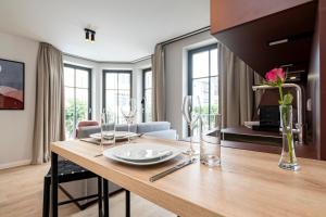 een eetkamer en een woonkamer met een houten tafel bij Gustav Appartements in Binz