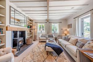 a living room with a couch and a fireplace at Bedgebury Oast by Bloom Stays in Goudhurst