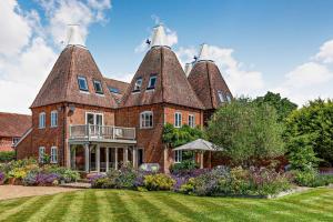 a large brick house with two large towers at Bedgebury Oast by Bloom Stays in Goudhurst