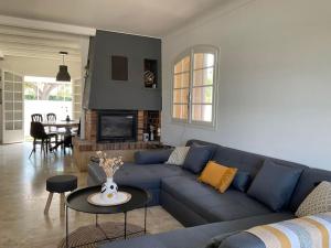 ein Wohnzimmer mit einem blauen Sofa und einem Tisch in der Unterkunft Villa - Saint Cyprien in Théza