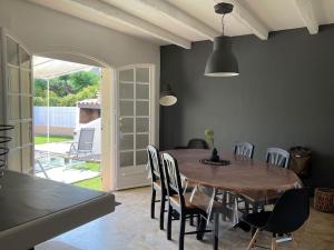 ein Esszimmer mit einem Holztisch und Stühlen in der Unterkunft Villa - Saint Cyprien in Théza