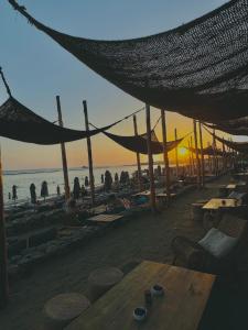 a beach with a table and chairs and people on the beach at WaveBreeze Villas in Paphos