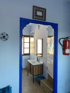 Baño azul con lavabo y espejo en Dar Besmellah, en Chefchaouen