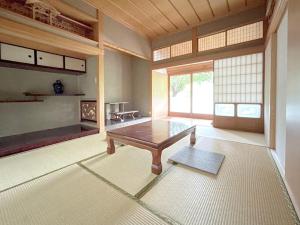 uma sala de estar com uma mesa no meio de uma sala em Yananose house em Dekiji