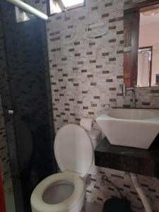 y baño con aseo y lavamanos. en Tapirandú Pousada, en Morro de São Paulo