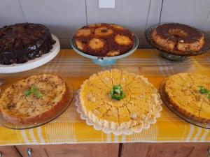 uma mesa com diferentes tipos de bolos e tortas em Tapirandú Pousada em Morro de São Paulo