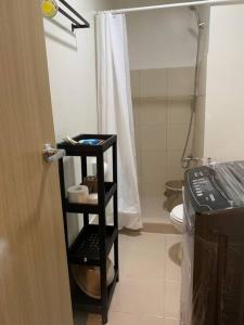 La salle de bains est pourvue de toilettes et d'une étagère noire. dans l'établissement Vito’s Freedom House, à Manille
