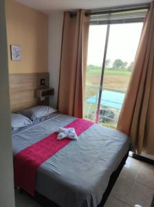 - une chambre avec un lit doté d'une couverture rouge et d'une fenêtre dans l'établissement BRISAS DEL QUINDIO N1APTo 307B, à Montenegro