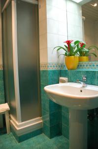 uma casa de banho com um lavatório, um espelho e uma planta em Benny Hotel em Catanzaro