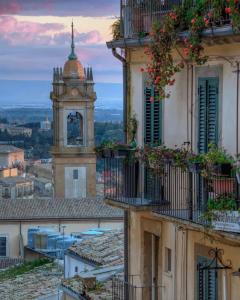 カルタジローネにあるCasa tipica siciliana patronale home BedandBreakfast TreMetriSoprailCielo Camere con vista, colazione interna in terrazzo panoramicoの時計塔のある建物の眺め