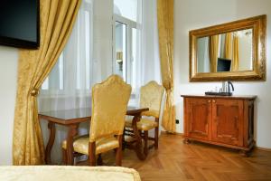 a dining room with a table and chairs and a mirror at Charles Bridge Palace in Prague