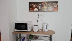 a microwave sitting on top of a table at Dunakeszi Nap Apartman in Dunakeszi