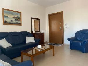 a living room with two blue couches and a coffee table at Πανέμορφο διαμέρισμα δίπλα από το κέντρο! in Tríkala