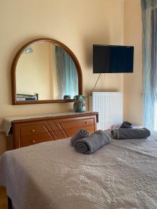 een slaapkamer met een bed, een dressoir en een spiegel bij Πανέμορφο διαμέρισμα δίπλα από το κέντρο! in Tríkala