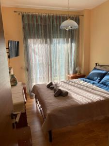 een slaapkamer met een groot bed en een groot raam bij Πανέμορφο διαμέρισμα δίπλα από το κέντρο! in Tríkala