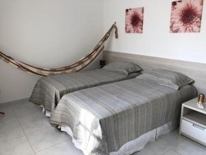 dos camas sentadas una al lado de la otra en un dormitorio en Casa Paradise Fiore, en Paripueira