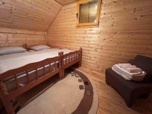 ein Schlafzimmer mit einem Bett in einem Blockhaus in der Unterkunft Vikendica Green Forest, Zenica in Zenica