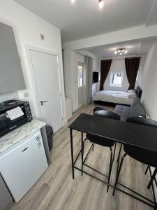 Zimmer mit einem Bett und einem Schreibtisch in einem Zimmer in der Unterkunft Large studio flat with garden in Teddington