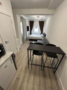 a living room with a table and a bedroom at Large studio flat with garden in Teddington +19 photos