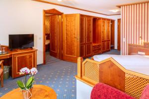 um quarto de hotel com uma cama e uma televisão em Parkhotel an der Therme em Bad Krozingen