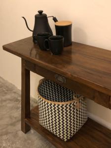 une table en bois avec deux tasses et un panier dans l'établissement OUTSIDE bungalow, à Sekongkang