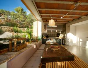 a kitchen and living room with a wooden table at Villa Masia Capdet in Sant Pere de Ribes
