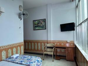 a bedroom with a bed and a desk and a tv at Tien Dat Motel in Pleiku