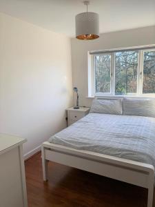 Habitación blanca con cama y ventana en Wokingham - Large 2 bedroom Apartment, en Wokingham
