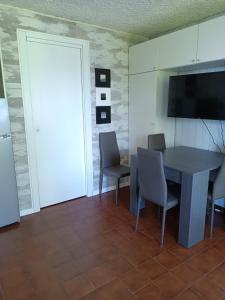 a dining room with a table and chairs and a television at margue residence meledrio in Folgarida