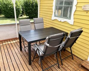 une table et des chaises noires sur une terrasse dans l'établissement Cozy cottage close to Farjestaden, à Färjestaden
