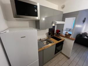 una pequeña cocina con fregadero y microondas en Serenity House, à 30 min de paris, en Grigny