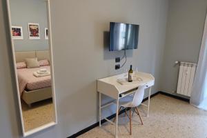 um quarto com um espelho, uma mesa e uma cama em Granny House em La Spezia