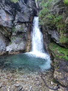 una cascada en un cañón con una piscina de agua en margue residence meledrio, en Folgarida
