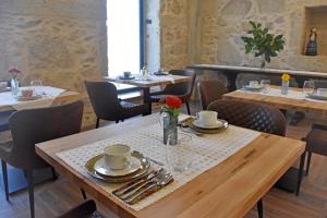un restaurante con mesas de madera y sillas con platos y tazas en Alminhas da Mindua, en Vitorino dos Piães