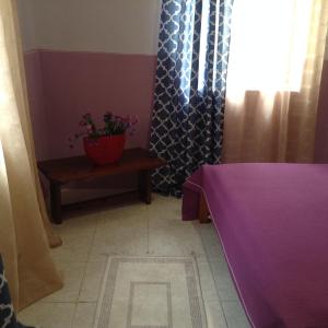 a room with a table and a potted plant and a window at Η in Volos