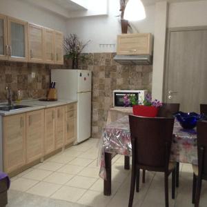 a kitchen with a table and a white refrigerator at Η in Volos