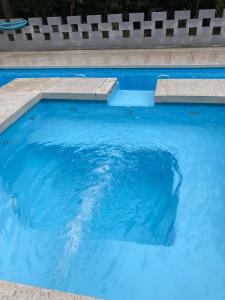 a swimming pool with blue water and two steps at Los Pinos Mina Clavero in Mina Clavero