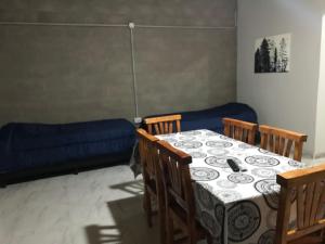 Habitación con mesa, sillas y sofá en Los Pinos Mina Clavero en Mina Clavero