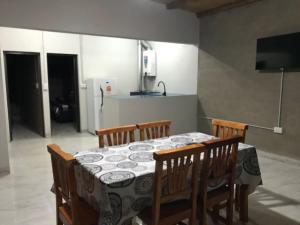 a dining room table with four chairs and a television at Los Pinos Mina Clavero in Mina Clavero