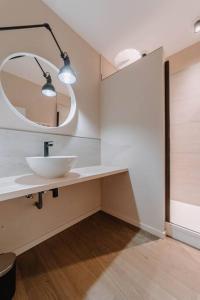 y baño con lavabo blanco y espejo. en Chimay : La Chambre Bleue de la Grand Place, en Chimay