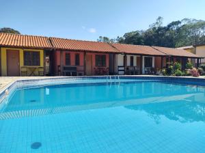 a swimming pool in front of a house at Fazenda Jorge Tardin in Barra Alegre