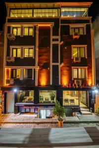 ein Gebäude mit Leuten, die nachts auf den Balkonen sitzen in der Unterkunft Gul Otel in Istanbul