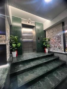 un hall d'ascenseur avec des escaliers et une porte ornée de plantes dans l'établissement ĐÔNG NHƯ HOTEL, à Hô-Chi-Minh-Ville