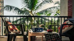 een tafel met twee stoelen en twee kopjes op een balkon bij Goa Chillout Apartment - 1BHK, Baga in Baga