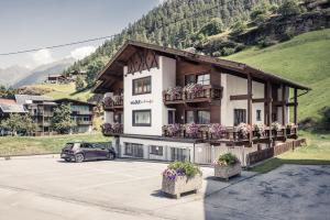 un edificio con flores en un estacionamiento en Madle - B&B, en Sölden