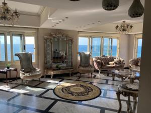 una gran sala de estar con sillas y mesa. en Luxury apartments in sanstefano en Alexandría